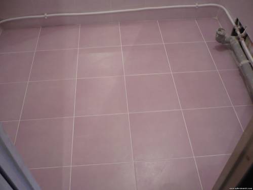 Укладка плитки на пол в ванной комнате.
